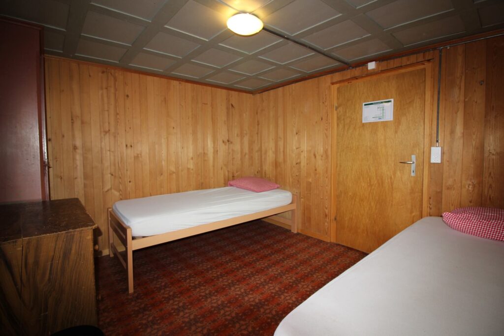 Zimmer mit Holztäfer und Betten