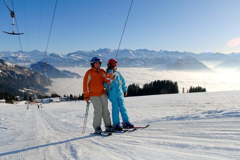 Skifahrer am Skilift mit Alpenpanorama