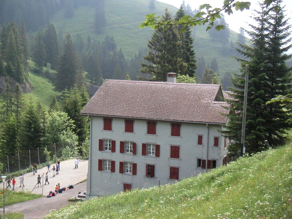 Das Haus im Sommer mit Hartplatz und Wiese