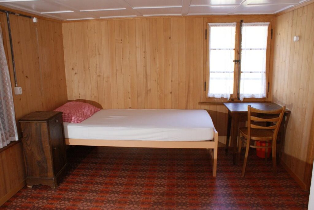 Zweierzimmer mit Holztäfer und Holzbett